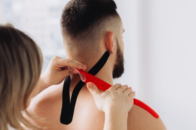 Eine Person trägt eine rote und schwarze Tape am Nacken.